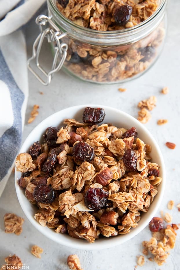 Granola is a small bowl with a white and blue stripped kitchen towel