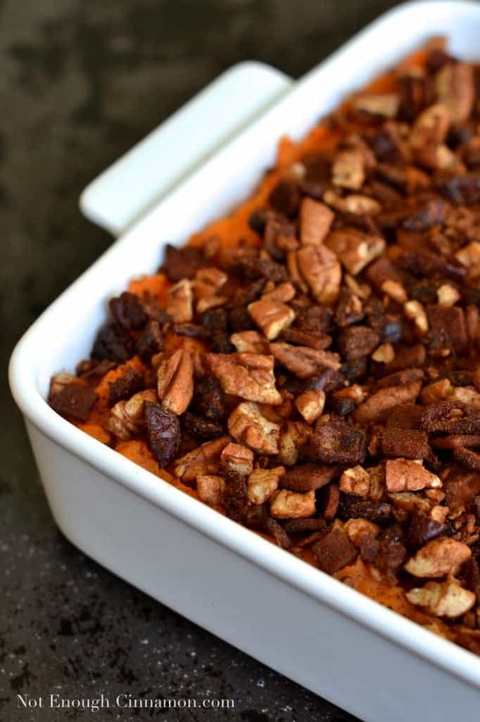 Sweet Potato Casserole with Pecans, Cranberries and Bacon sprinkled on top, served in a white casserole dish