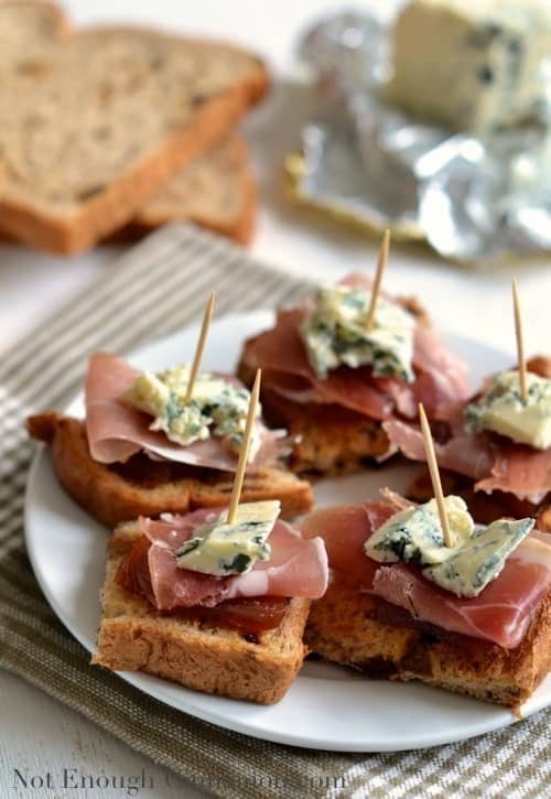 Spanish Quince, Prosciutto and Blue Cheese Pintxos served on a white plate held together with toothpicks