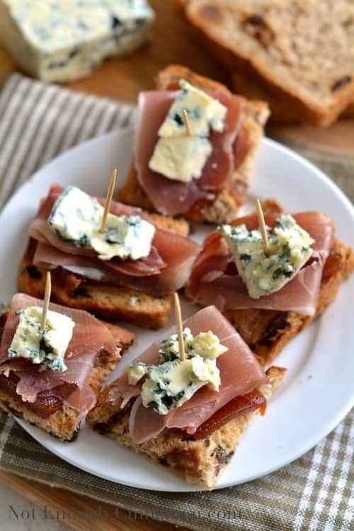 Quince, Prosciutto and Blue Cheese Pintxos served on a white plate with toothpicks holding them together