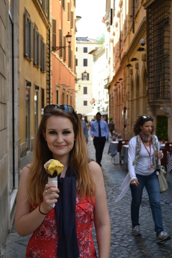 a woman holding an ice cream cone in the streets of Rome
