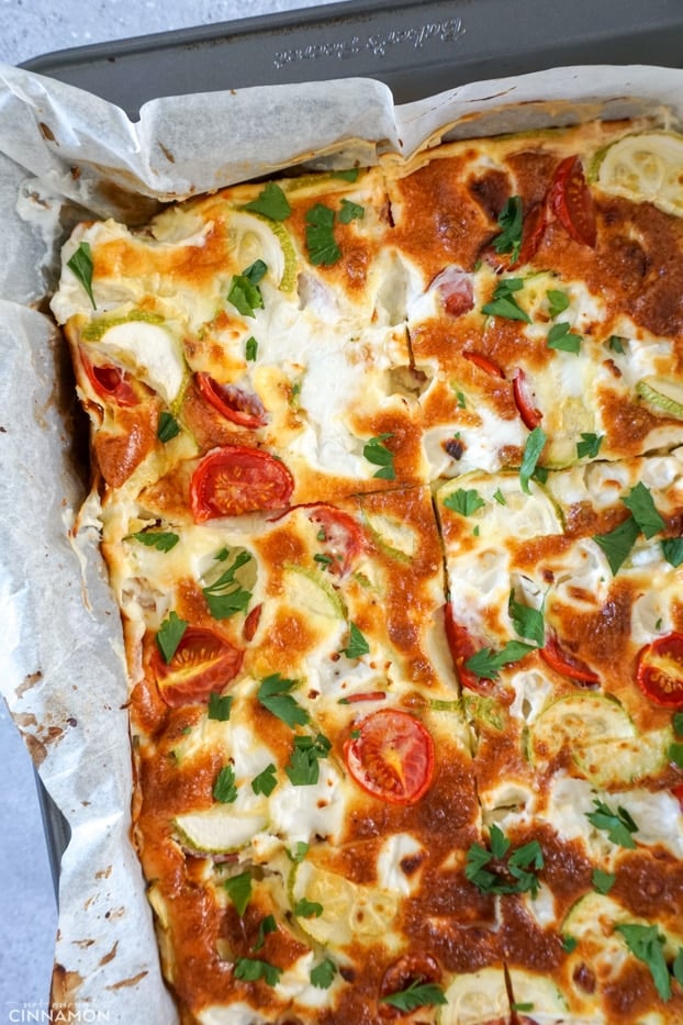 Baked Frittata in a metal square pan lined with parchment paper.