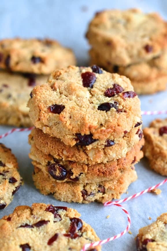 Healthy Cranberry and Macadamia studded Paleo Cookies stacked on top of each other on parchment paper
