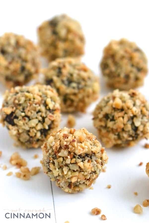 Ferrero Rocher Copycat Healthy Energy Balls with chocolate and hazelnuts on a white tabletop 