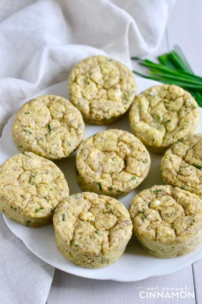 a plate of Gluten Free Zucchini Muffins with feta and chives on a white table