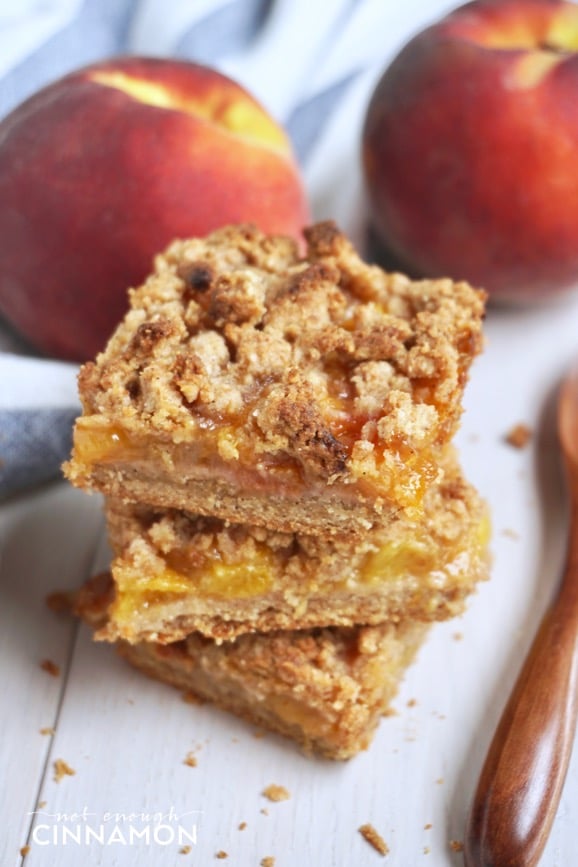 three stacked healthy peach crisp bars on a white table