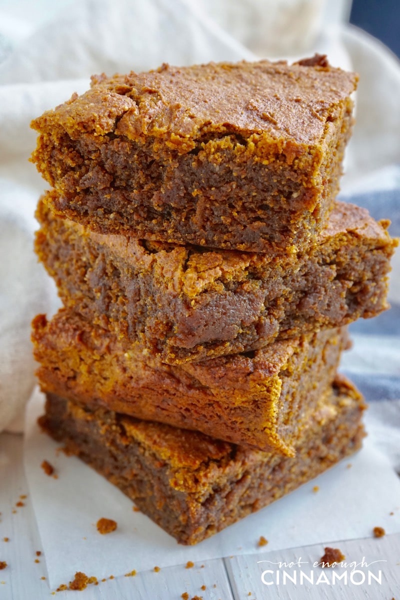 A stack of four Paleo Pumpkin Blondies on a piece of parchment paper