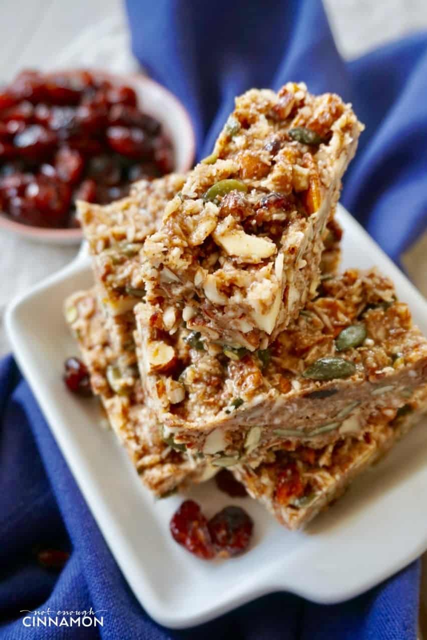 Overhead shot of No Bake Cranberry Pumpkin Spice Healthy Snack Bars stacked on a white plate