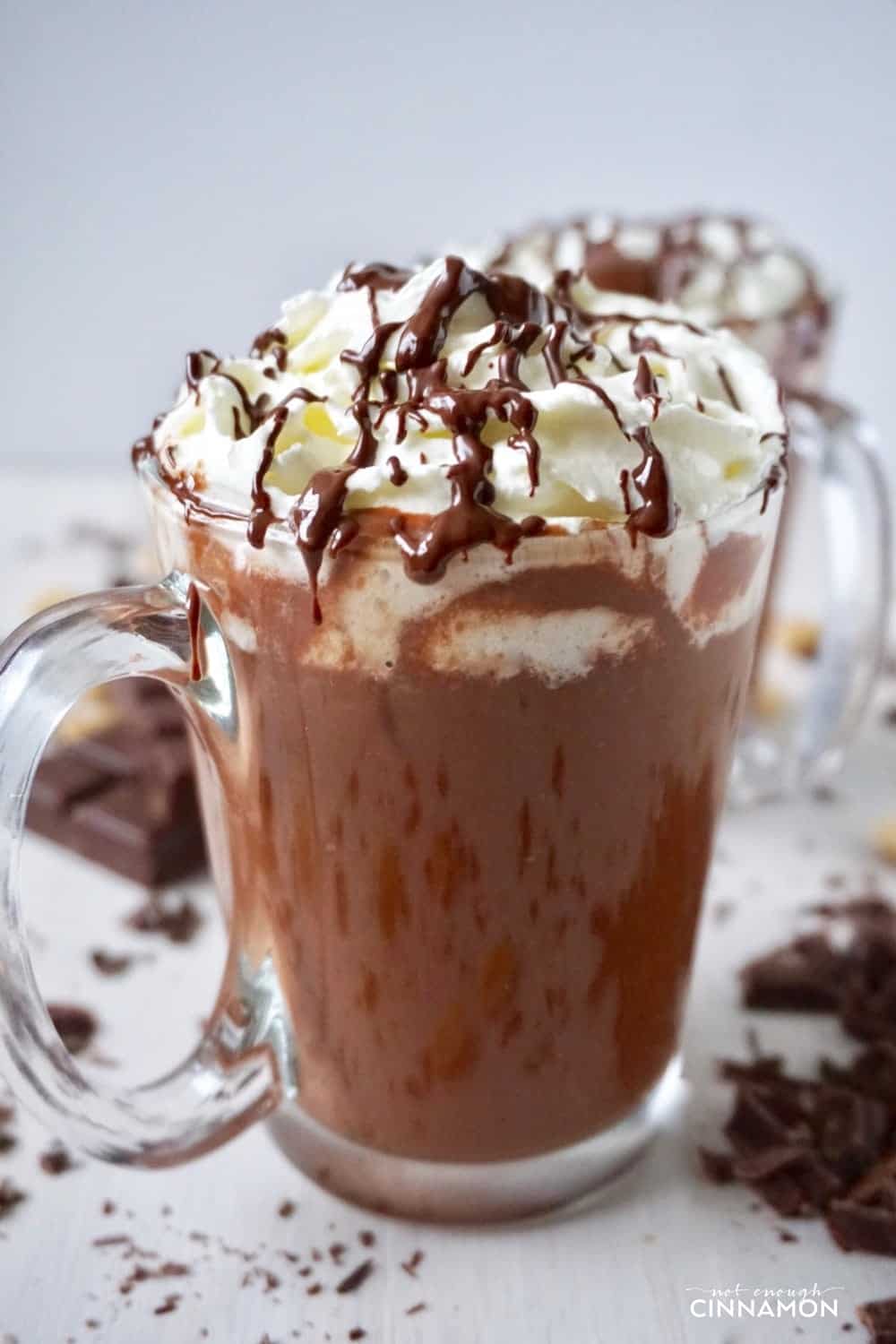 side view of a mug of Healthier peanut hot chocolate topped with whipped cream and chocolate sauce