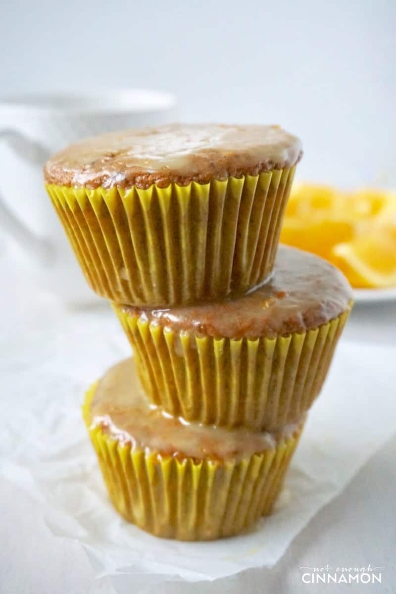 three stacked gluten-free orange poppy seed muffins with vanilla glaze