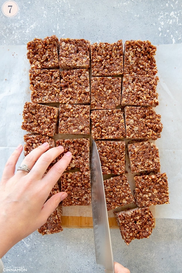 Chocolate rice krispies treats cut in squares with a large knife