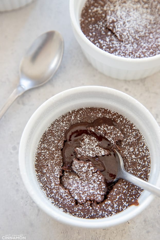 overhead shot of a single serving molten chocolate lava cake in a small ramekin with a silver spoon sticking in 