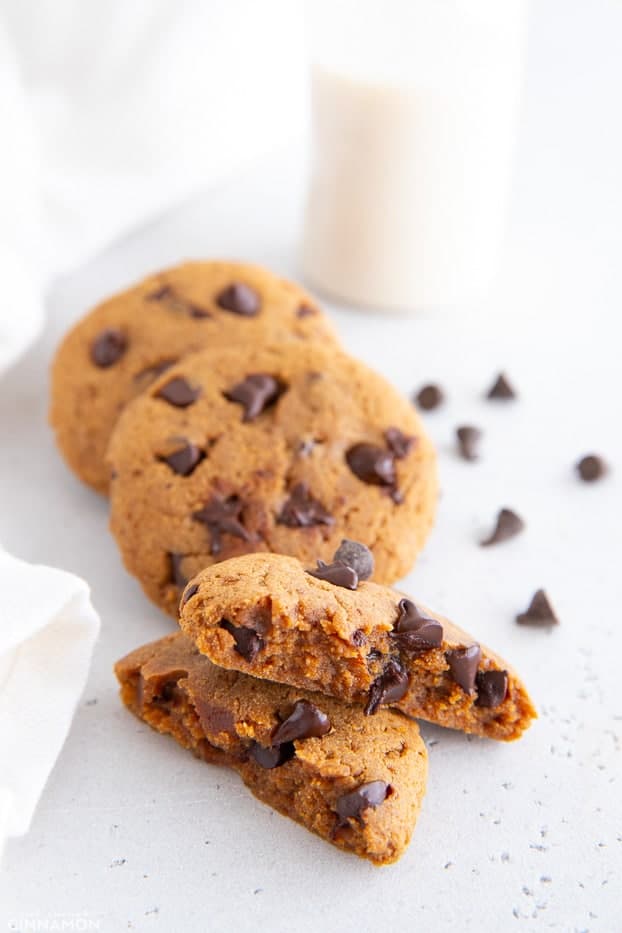 healthy 5 ingredient protein cookies with dark chocolate chips and a glass of milk in the background 