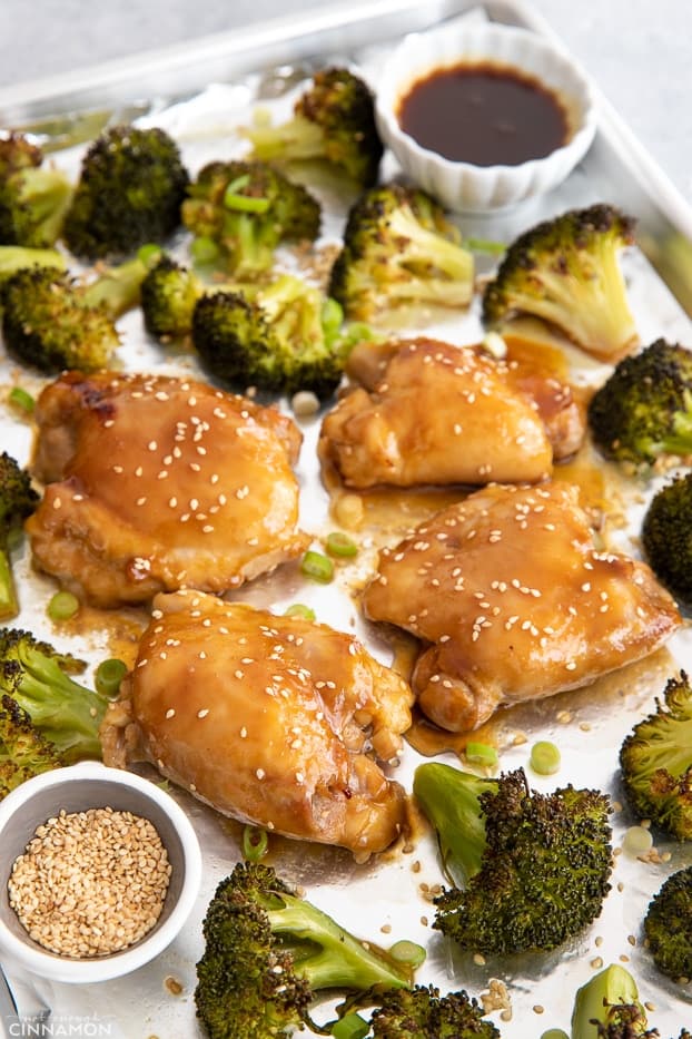sesame sprinkled Asian glazed Teriyaki chicken thighs with broccoli on a sheet pan 