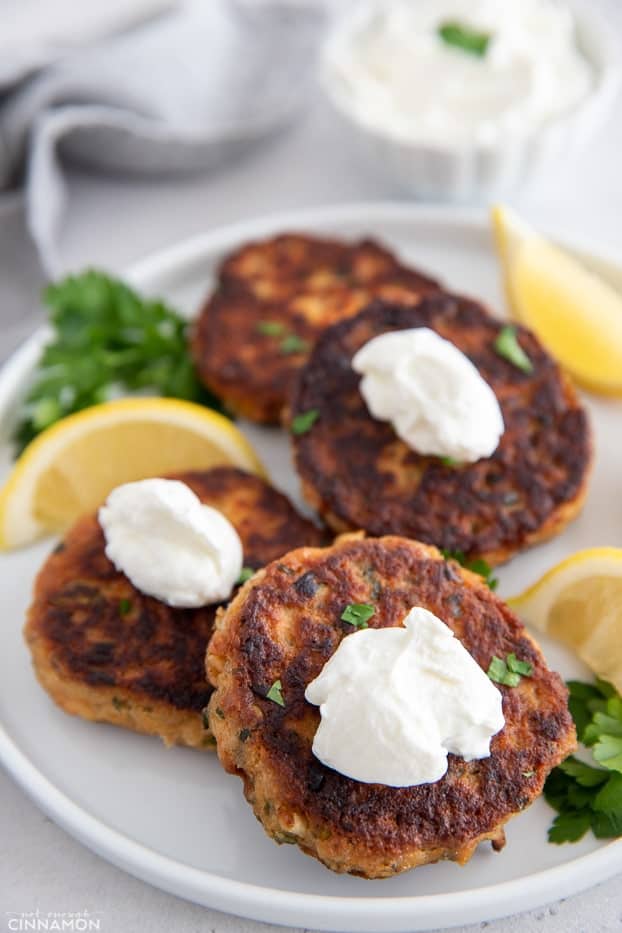 healthy whole30 salmon patties on a white plate topped with sour cream