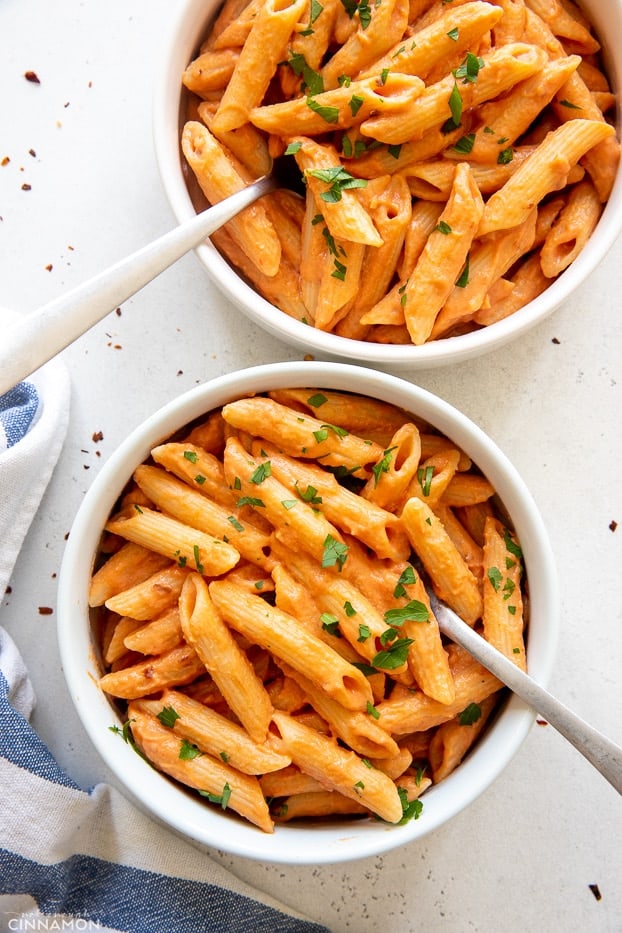 overhead shot of two bowls of vegan dairy free penne pasta alla vodka