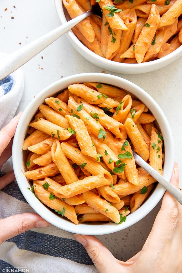 overhead shot of two bowls with dairy-free penne vodka sprinkled with parsley