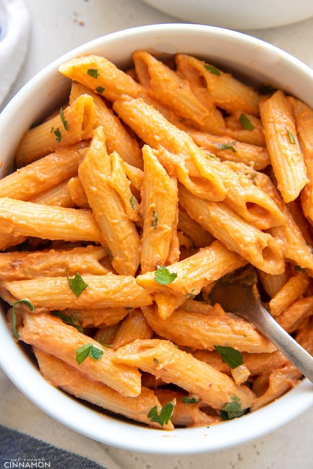 overhead shot of a bowl of vegan dairy free penne vodka in a white bowl