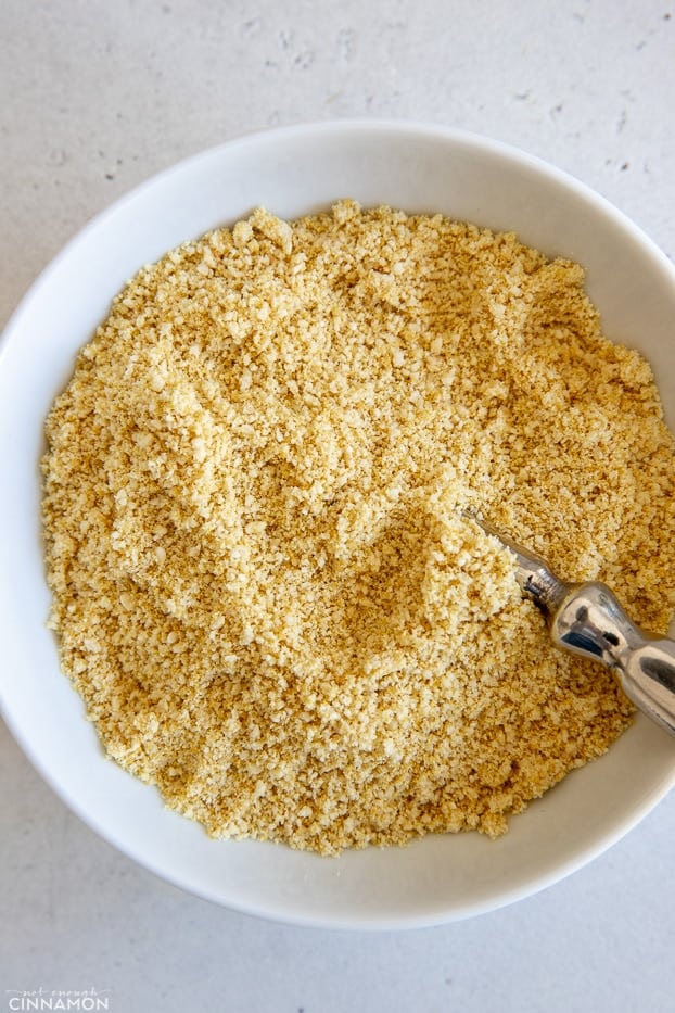 overhead shot of a white bowl filled with vegan parmesan cheese 