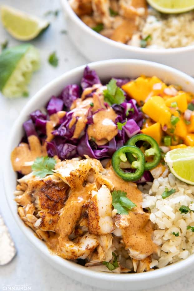 side view of a healthy fish taco bowl with mango salsa and cilantro lime cauliflower rice 