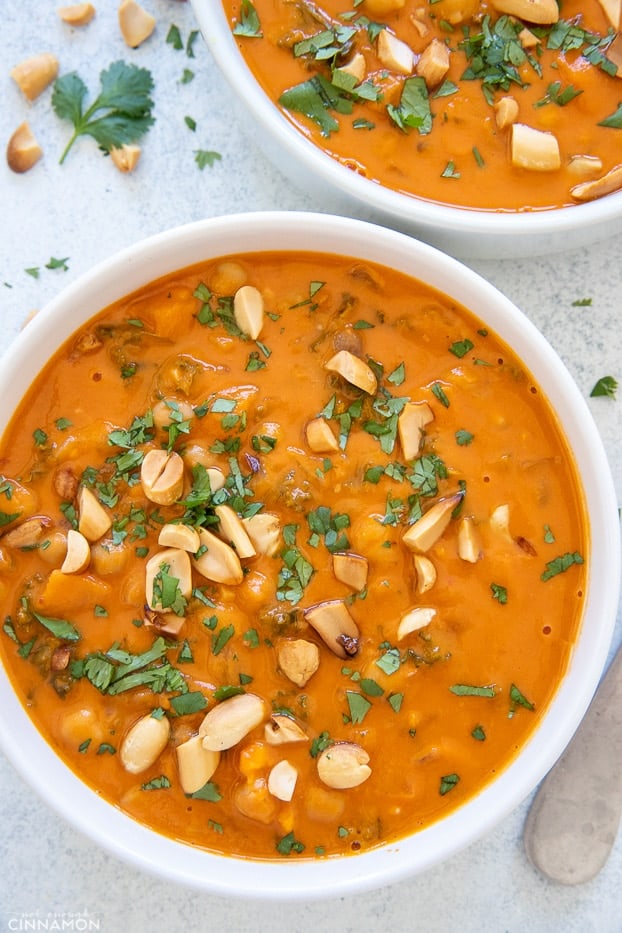 overhead shot of a bowl of West African Peanut Soup sprinkled with peanuts and cilantro