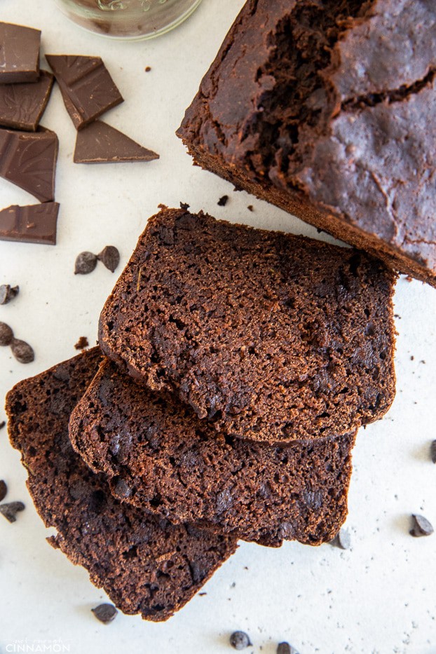 three slices of moist gluten-free chocolate zucchini bread surrounded by chocolate chips