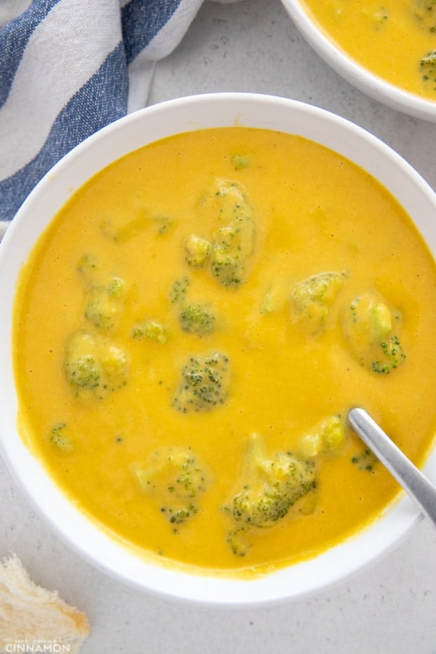 a bowl with vegan broccoli cheese soup with a spoon 