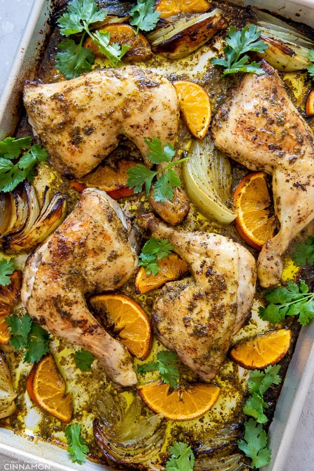 Cuban Mojo Chicken on a sheet pan along with cilantro and orange
