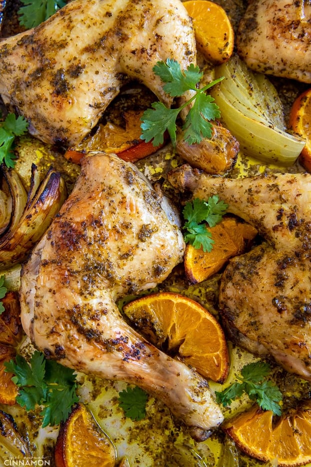 tender juicy chicken pieces roasting on a sheet pan along with orange slices