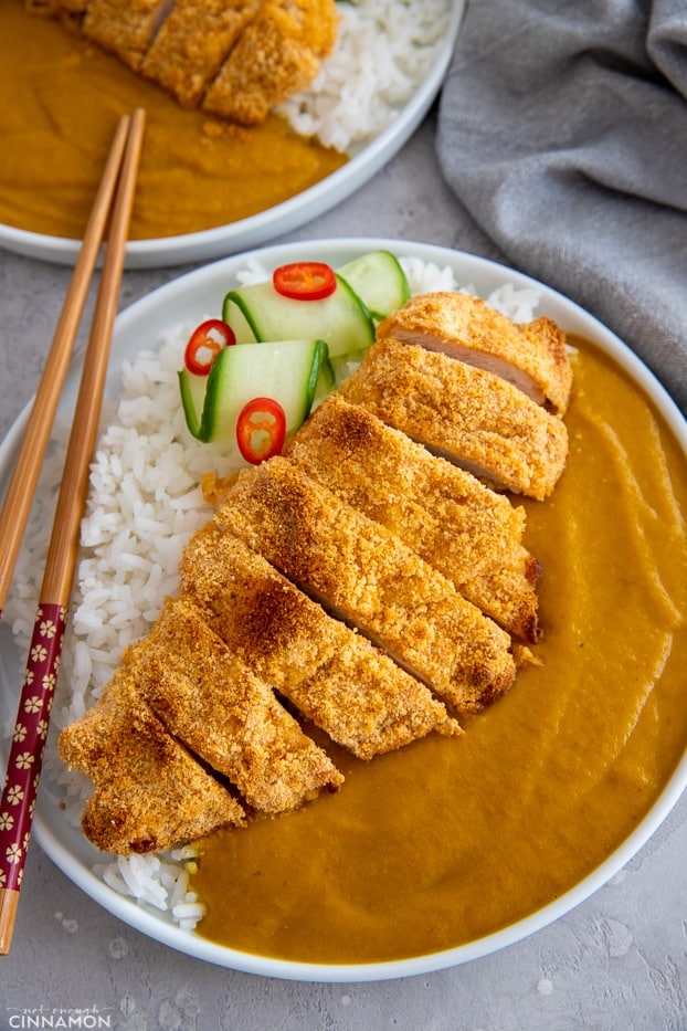 a serving of healthy paleo chicken katsu curry served with cucumber and a mild curry sauce