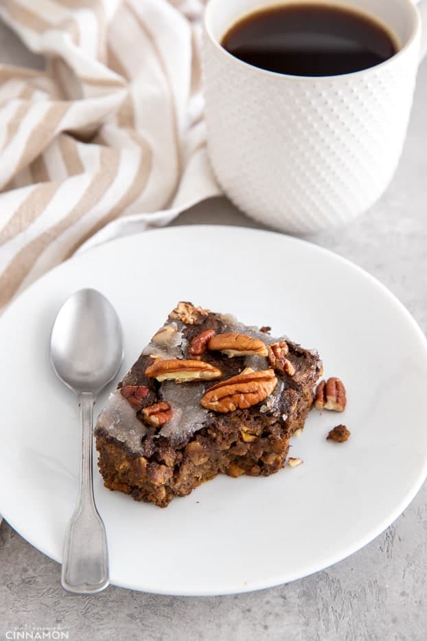 a square of vegan gingerbread baked oatmeal with a spoon on the side