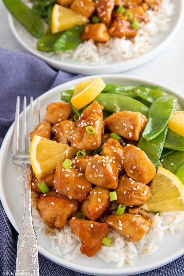 sticky one skillet orange chicken served over rice with a side of snow peas 