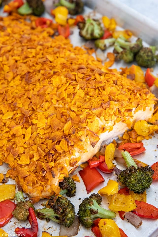 salmon fillet baked with a crust of crushed sweet potato chips surrounded by baked vegetables
