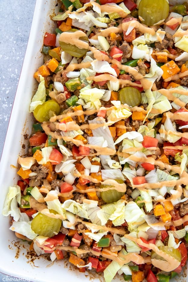 a white casserole dish with healthy BLT burger casserole drizzled with special sauce