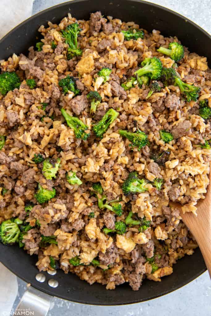 Healthy Asian Beef and Broccoli Fried Rice being stir-fried in a big skillet