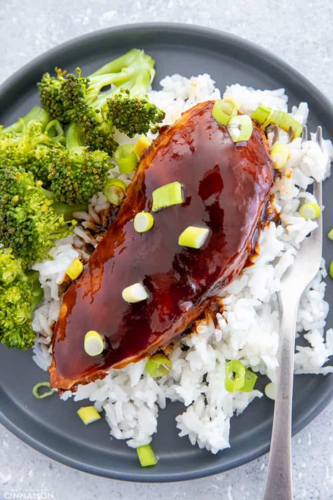 overhead shot of baked Chinese Firecracker Chicken served over rice with a side of steamed broccoli