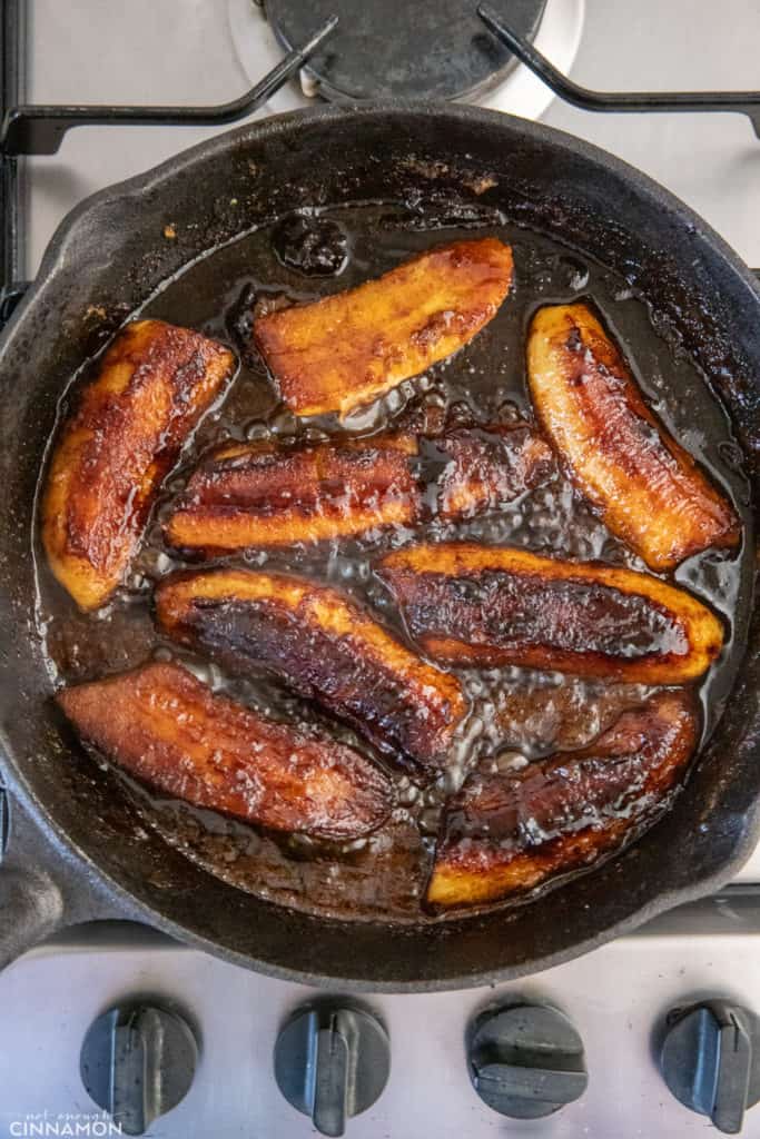 overhead shot of a black skillet with caramelized bananas in rum caramel sauce 