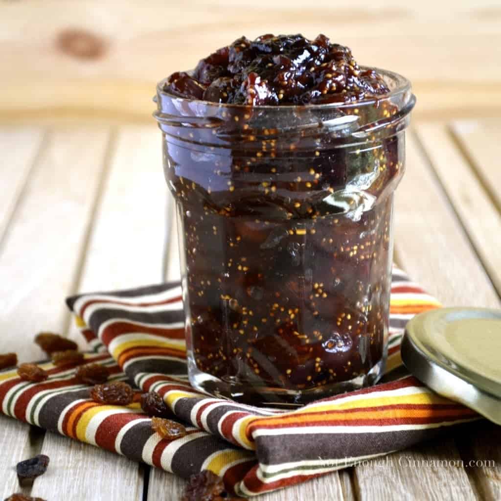 side view of Fresh Fig Chutney in a glass jam jar on a striped kitchen towel