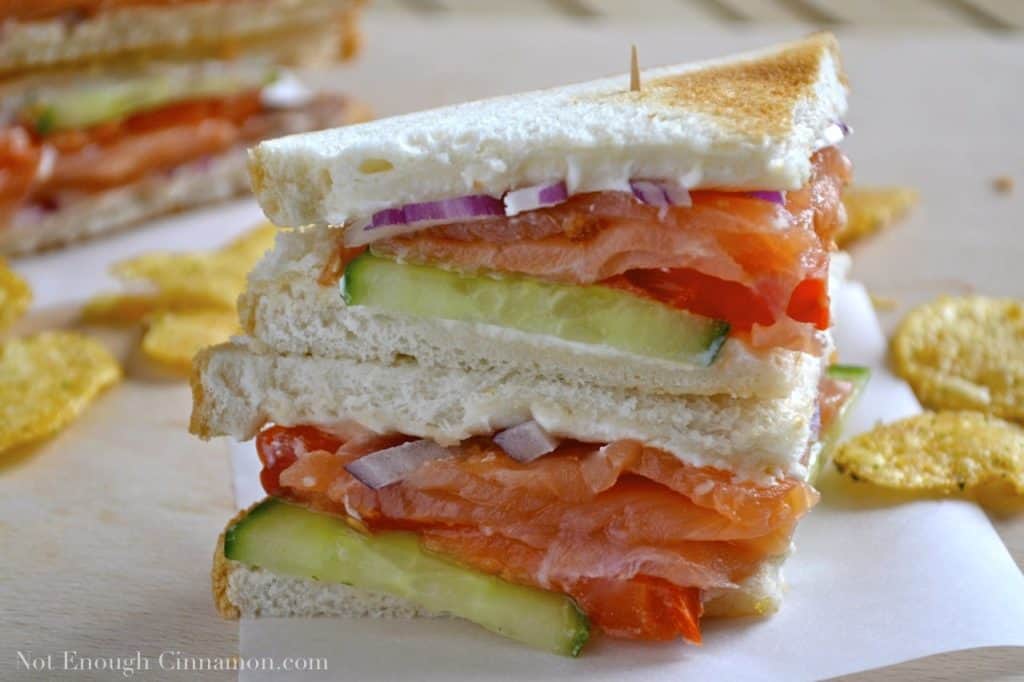 Smoked Salmon Club Sandwiches stacked on top of each other with a toothpick