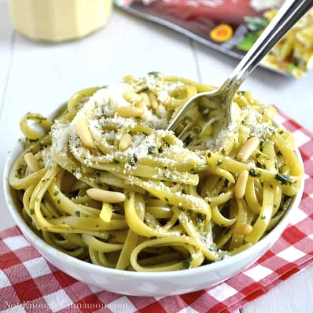 Skinny Pesto Cream Pasta with grated Parmesan on top, served in a white bowl 