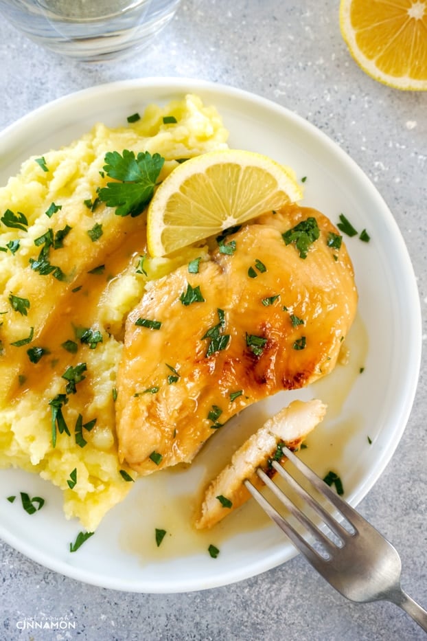 Lemon basil chicken breast with a piece cut, over mashed potatoes