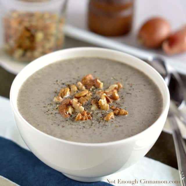 Skinny Cream of Mushroom Soup served in a white bowl with some chopped walnuts and freshly grated pepper on top