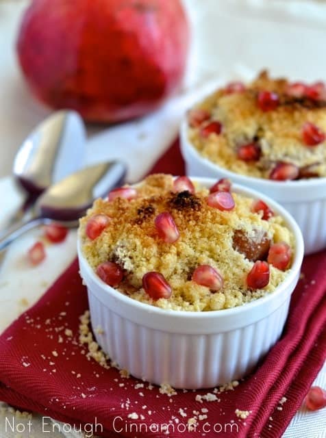 Pear and Pomegranate Crumble served in individual white ramekins sprinkled with pomegranate seeds