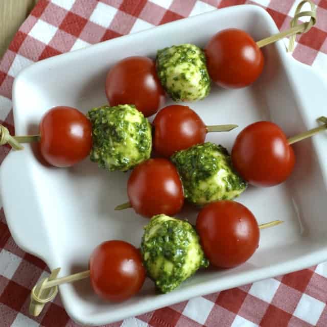 Tomato, Pesto and Mozzarella Skewers served on a white plate