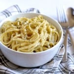 Blue Cheese Pasta sprinkled with cracked pepper, served in a white bowl on a striped napkin