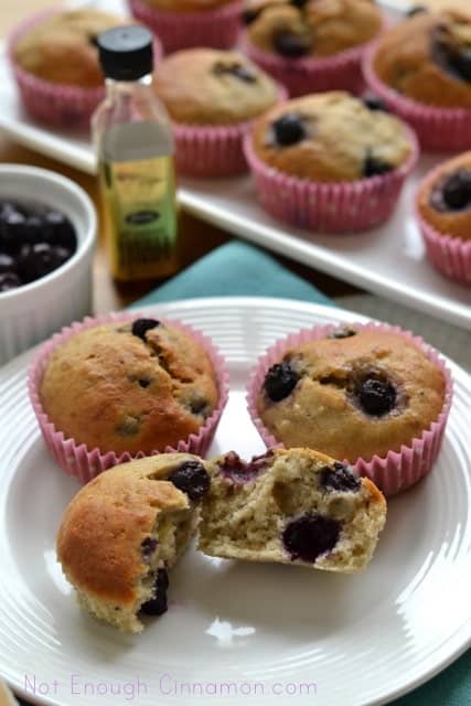 Blueberry Banana Bread Muffins served on a white plate with the front muffin being torn into halves to reveal the moist, fluffy centre.