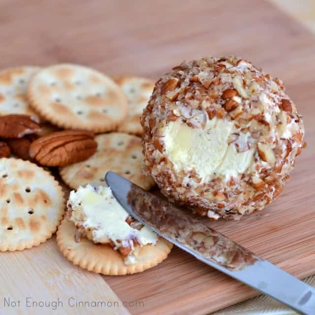 a small portion of Pecan Cheese Balls being spread on a Ritz Cracker with a butter knife