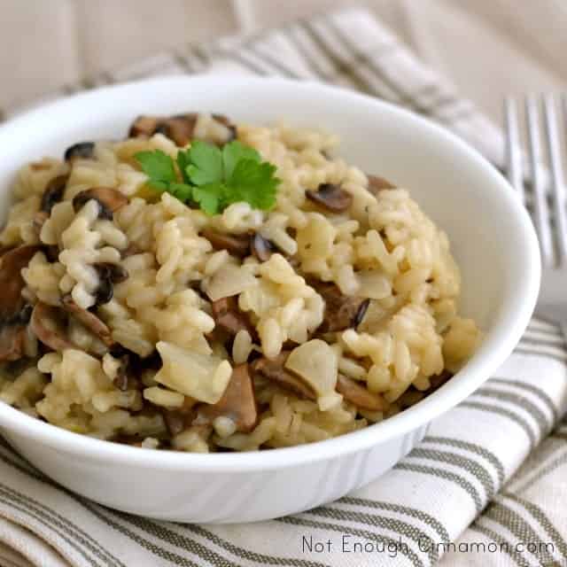 creamy mushroom risotto served in a white bowl with some fresh parsley on top
