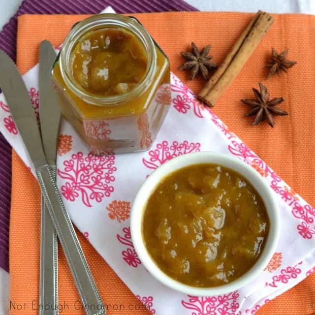 Mango Apple Chutney served in a small white bowls with a open jar of chutney and some whole spices in the background