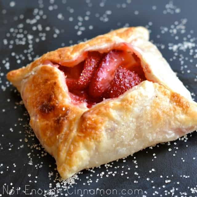 Mini Strawberry Pie dusted with granulated sugar, served on a black table